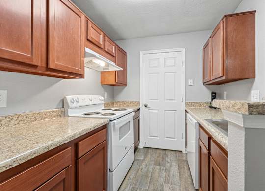 A kitchen with white appliances and wooden cabinets.